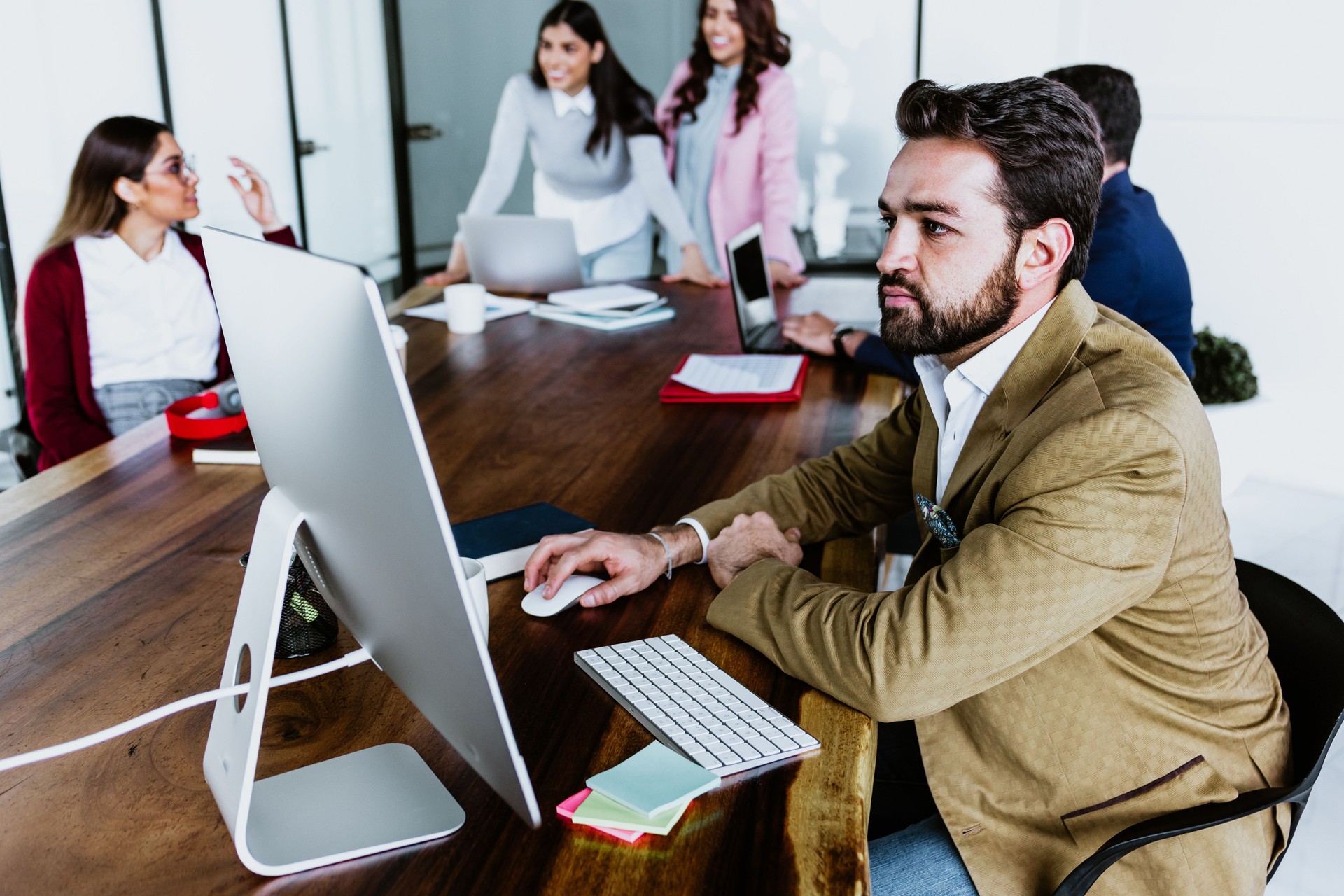Joven empresario latino trabajando y usando computadora de escritorio con ropa casual inteligente en la oficina en México, hispanos